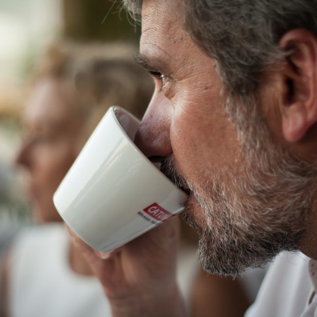 Detalle de un hombre bebiendo café en una taza de Catunambú