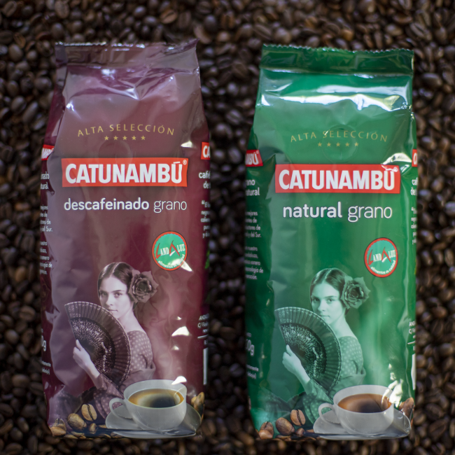 Detalle de los paquetes de grano Alta Selección Descafeinado y Natural, con granos de café de fondo
